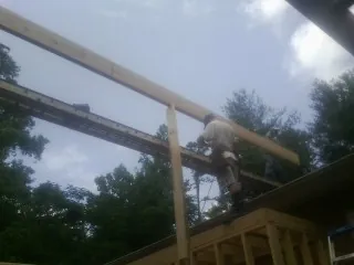 Carpenter setting a ridge beam over a new addition frame — Ice Dam Removal by Roofing Brothers in Carthage